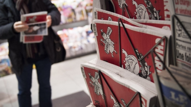 un lettore acquista l'ultimo numero della rivista satirica Charlie Hebdo