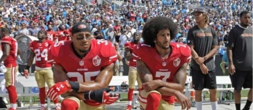Colin Kaepernick (right) protesting the American national anthem - vancouversun.com