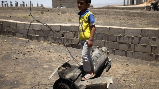 Un petit gar&ccedil;on joue sur un morceau d'obus qui a explos&eacute; pr&egrave;s de son domicile - PHOTO: UNICEF/MOHAMED HAMOUD