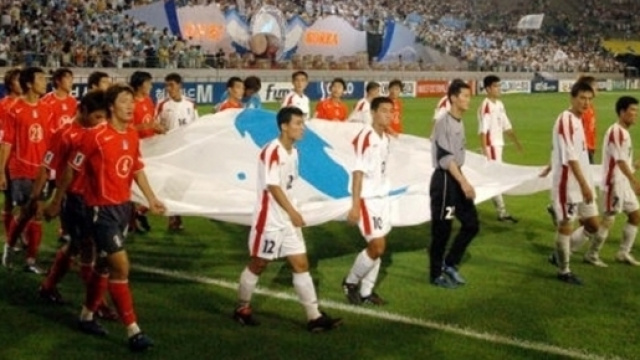 I giocatori delle due Coree entrano in campo reggendo la 'bandiera della riunificazione'