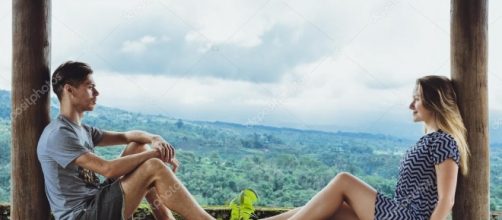 Hombre joven y mujer disfrutando sentado en un alto ... - depositphotos.com