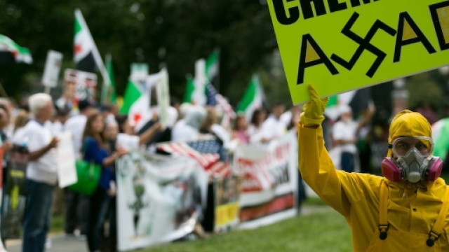 Un manifestante denuncia l'uso di armi chimiche da parte del dittatore siriano