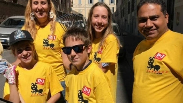 Alcune magliette gialle Pd armate di ramazza per pulire i rifiuti di Roma