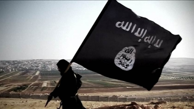 Un combattente jihadista con la bandiera dell'Isis