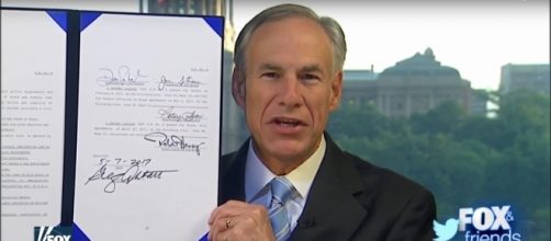 Texas Republican Gov. Greg Abbott shows signed SB4 bill Image screencap via Fox News/YouTube