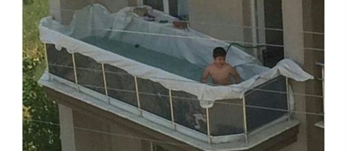 Menino brinca na piscina improvisada na sacada de um apartamento (Foto: Reprodu&ccedil;&atilde;o)