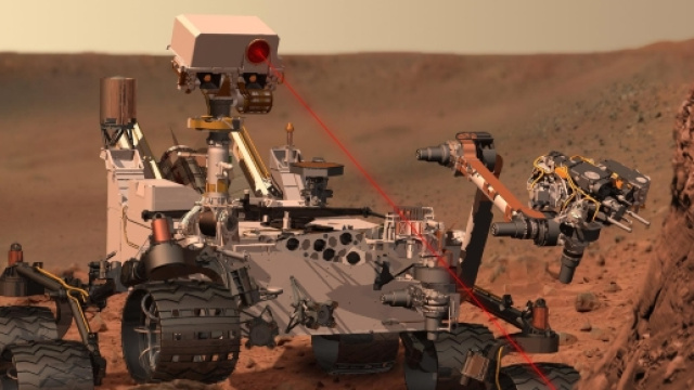Un rendeering di Curiosity mentre punta il suo spettrometro laser sul suolo marziano