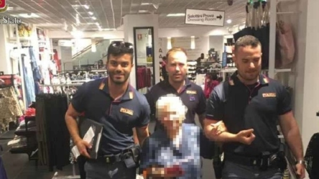 La nonnina esce dai magazzini dove aveva rubato un profumo 'scortata' da tre agenti della polizia di Stato.