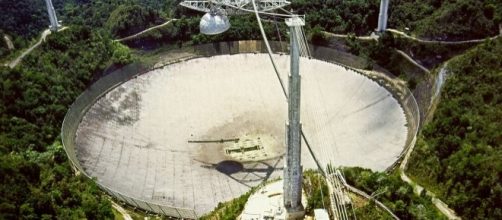 The Arecibo Radio Telescope, at Arecibo, Puerto Rico by H. Schweiker/WIYN and NOAO/AURA/NSF via Wikimedia Commons