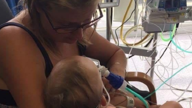 Chrissy Lennon con il figlio Ollie completamente intubato dopo aver ingerito una pila a bottone. Foto: Facebook.