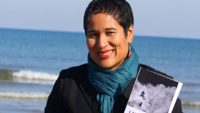 la scrittrice e attivista politica Ilka Corado mostra sorridendo uno dei suoi libri