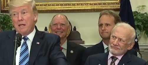 Buzz Aldrin's puzzled looks steal the show from behind Trump. Photo: YouTube Screenshot