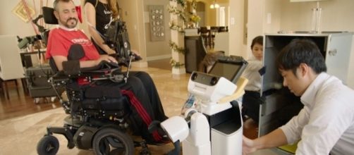 Army veteran Romy Camargo watches as the Toyota Home Support Bot is prepped. - anith.com