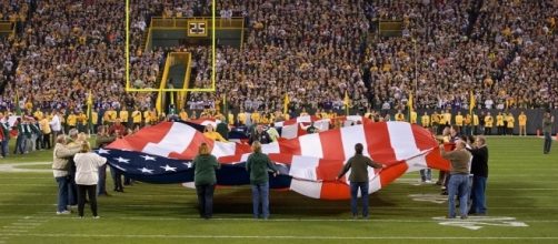 A patriotic ceremony before the national anthem at Lambeau Field. (Via Wikimedia Commons).