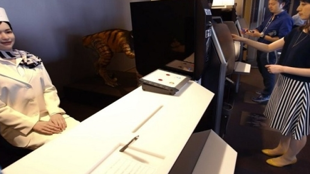 Clienti dell'hotel effettuano la registrazione dinnanzi ad una receptionista robot - Foto Shizuo Kambayashi/AP Images