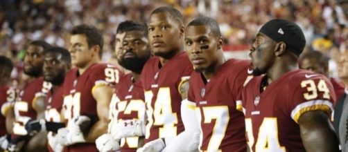 (Washington Redskins link arms in protest, courtesy BipHoo Company/Flickr)