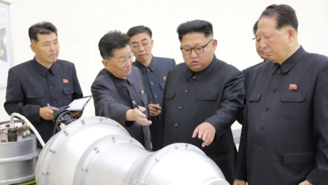 Kim Jong Un in visita ad un centro di ricerca nucleare davanti a quella che potrebbe essere una bomba H (foto KCNA)