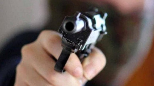 Un rapinatore con in mano la pistola