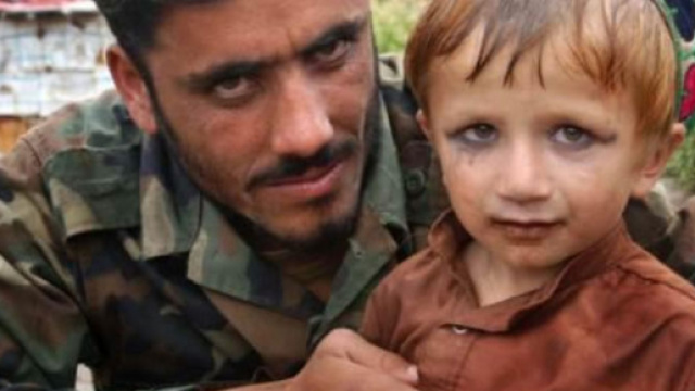 Un bambino afghano truccato da donna