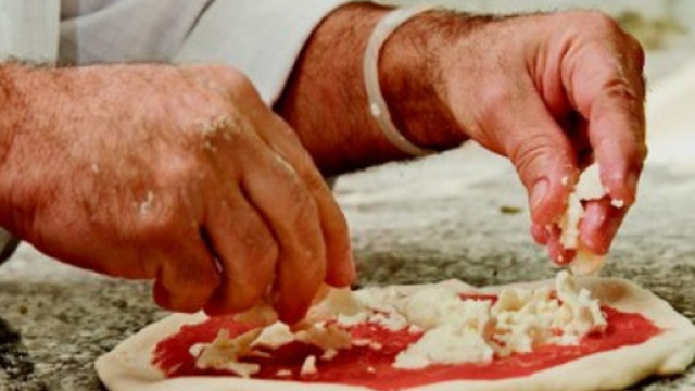 Un pizzaiolo prepara una pizza