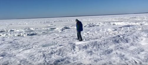 A man walks on the frozen ocean off Old Silver Beach - North Falmouth, MA. [image source: Ryan Canty / Youtube screenshot ]