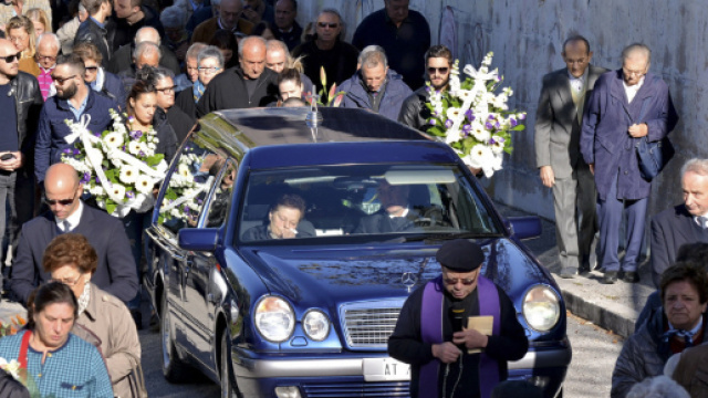 feretro seguito da parenti che va verso il cimitero