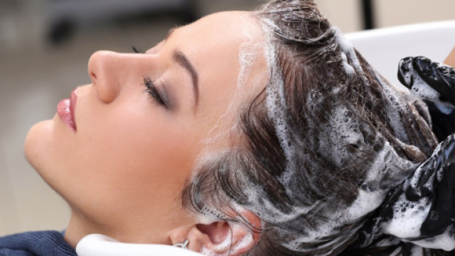 Una Donna a cui viene eseguito uno shampoo