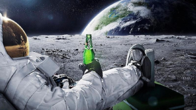In alto, astronauta intento a bere una birra