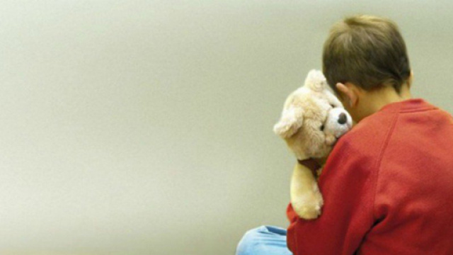 Bambino autistico tiene in braccio un pupazzo