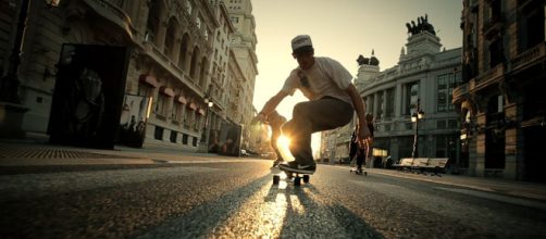 Usu&aacute;rios do longboard andando pela cidade.