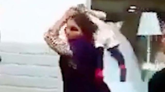 Un frame del video in cui appare il folle gesto della donna: usa il bambino come arma contro un uomo