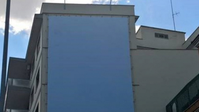 Il maxi poster di ProVita coperto da un telo bianco