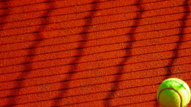 Una pallina da tennis sul campo di terra rossa