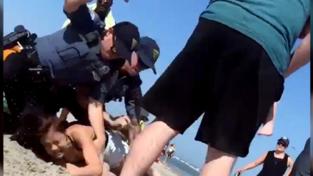 Pestaggio in una spiaggia del New Jersey: due agenti si scagliano contro una ragazza dopo un alterco.