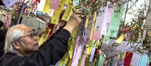 Idoso Japon&ecirc;s pendurando o seu pedido na "Tabata Matsuri"