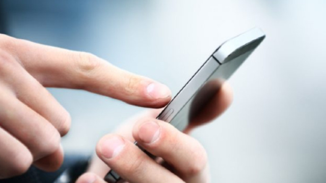 In alto, persona intenta a utilizzare uno smartphone