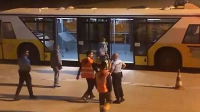 Il passeggero accompagnato dai medici su un pullman dopo l'atterraggio