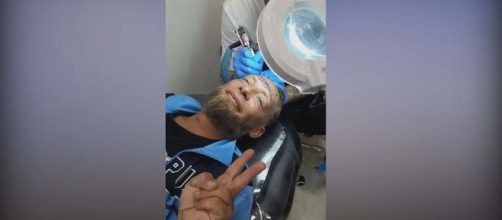 A group of men on a stag weekend paid a Polish homeless man to get a tattoo of the groom's name. [Image News Week/YouTube]