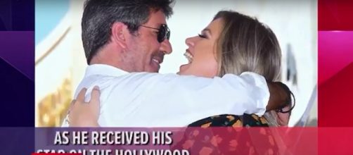 Kelly Clarkson gave warm words to Simon Cowell and got a warm hug at his Walk of Fame ceremony. - [Access / YouTube screencap]