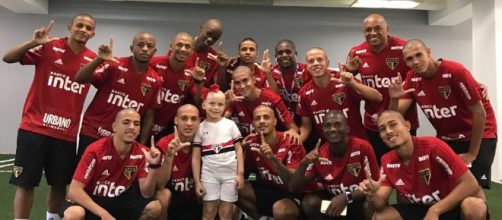 Pequena torcedora ao lado dos jogadores (Divulga&ccedil;&atilde;o SPFC).