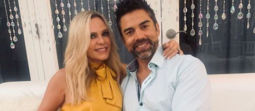 Tamra Judge and husband Eddie Judge pose together on a white couch. [Photo via Instagram]