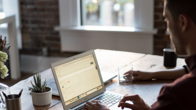 Jeune homme travaillant sur ordinateur dans un openspace
