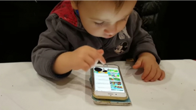 Bambino di un anno e mezzo che usa lo smartphone
