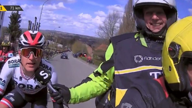 Lukas Postlberger aiutato da una moto alla Dwars door Vlaanderen.