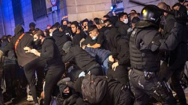 Covid-19, proteste a Barcellona contro restrizioni: distrutti negozi e scontri con la polizia.