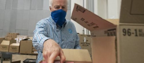 Cornyn wearing a facial covering while volunteering at a food bank in 2020. [Image via U.S. Department of Agriculture/Lance Cheung - Flickr]