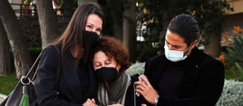 Esther Do&ntilde;a sostiene a su madre acompa&ntilde;ada por su hermano en el funeral de su padre