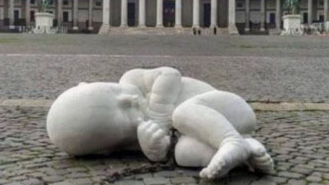 Homeless, bambino dallo sguardo triste rannicchiato in posizione fetale, &egrave; la macchia di purezza che sfida lo sguardo dei passanti.
