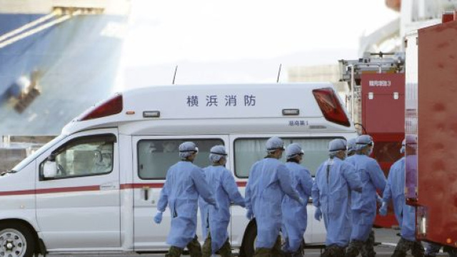 Personale medico mentre sale sulla nave attraccata al largo di Yokohama