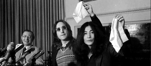 John Lennon y su esposa Yoko Ono agitan la bandera del nuevo pa&iacute;s, Nutopia, en la conferencia de prensa de Nueva York.